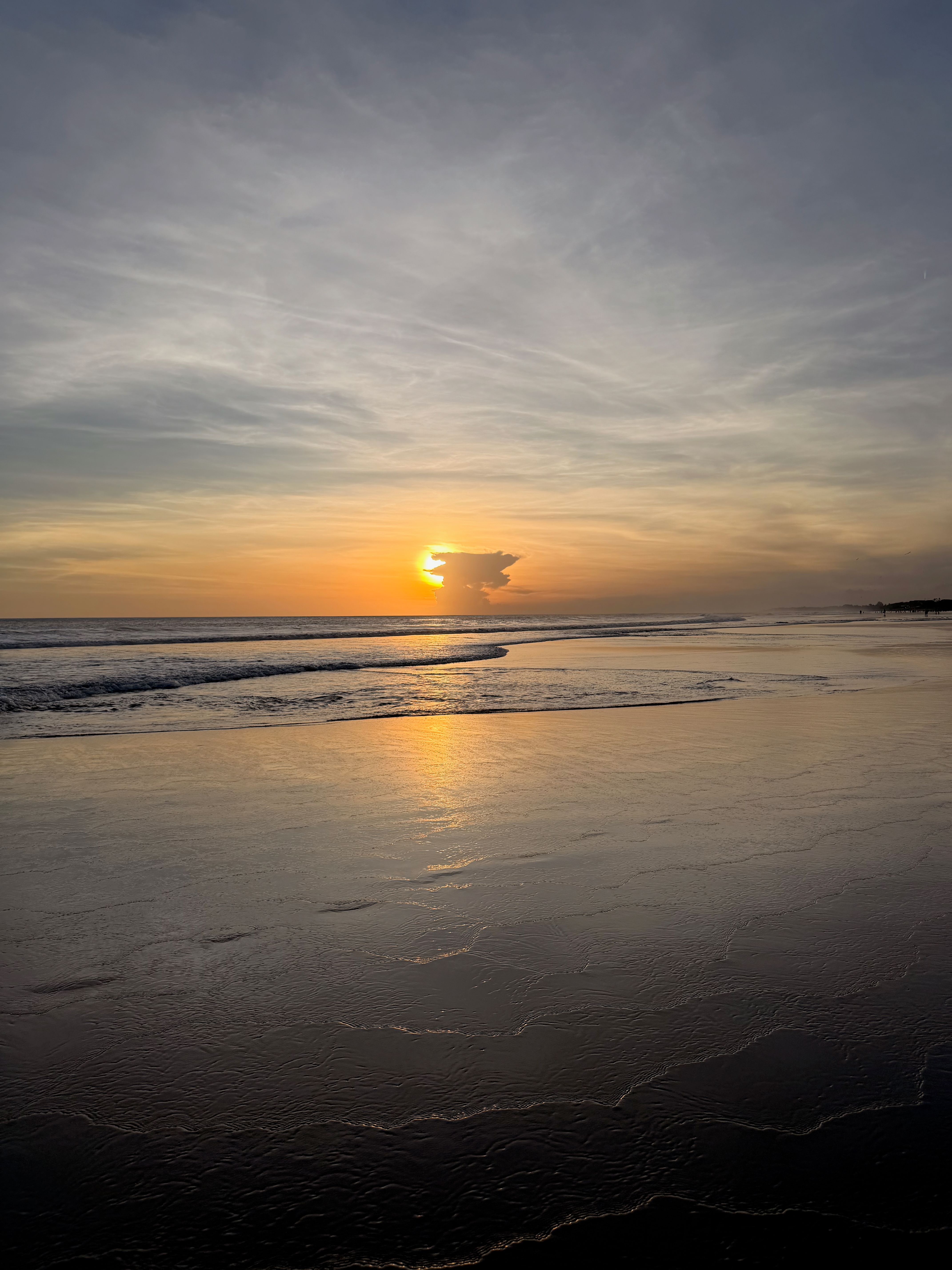 glassy beach surrounded by waves and a sunset